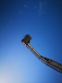 Low angle view of crane against blue sky