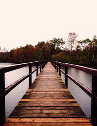 Pier over lake against clear sky