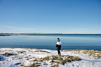 Full length of man standing in sea against clear sky