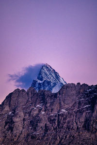 Rock formations against mountain range against clear sky