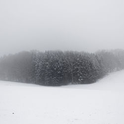 Scenic view of snow covered land against sky