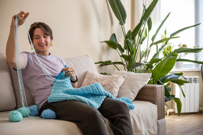 Young woman using laptop while sitting on sofa at home