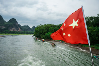 Scenic view of red flag on mountain against sky