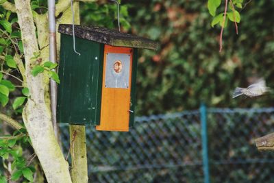 Close-up of birdhouse on wooden post