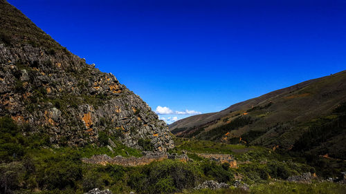 Scenic view of rocky mountains against blue sky