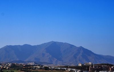 Scenic view of mountains against blue sky