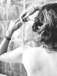 Full length of shirtless woman holding water