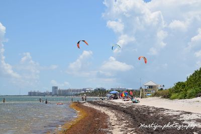 People on beach against sky