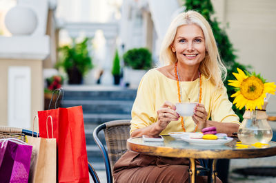 Young woman using mobile phone while sitting at restaurant