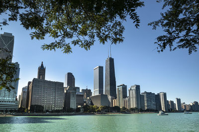 Sea by buildings against sky in city