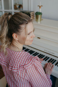 Young beautiful woman playing the piano. high quality photo