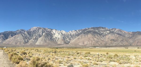 Scenic view of landscape and mountains against clear blue sky