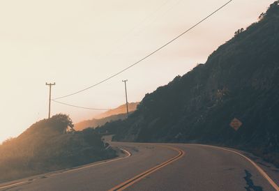 Road by mountain against sky