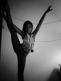 Portrait of smiling young woman standing against clear sky