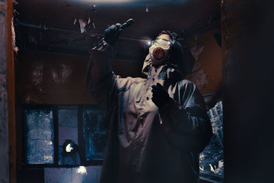 Fictional movie poster. people with flashlights, masks and protective clothing inspect old house. 