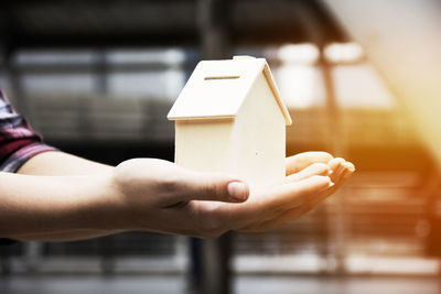 Cropped hand of woman holding birdhouse