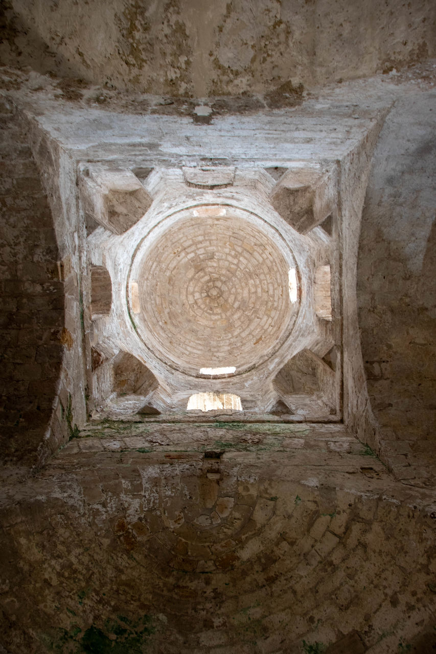 architecture, history, built structure, ancient history, no people, wall, the past, temple, geometric shape, circle, ancient, indoors, shape, old, day, building, wall - building feature, religion, travel destinations, nature, stone material, crypt, pattern