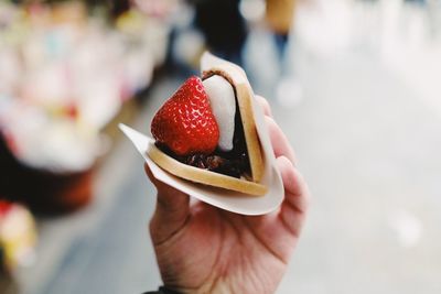 Close-up of hand holding ice cream