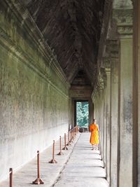 Rear view of person walking in corridor of building