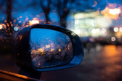 Reflection of illuminated car in side-view mirror