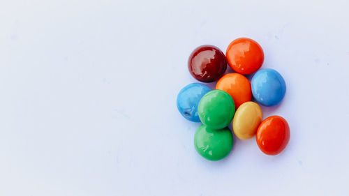 High angle view of multi colored candies on white background