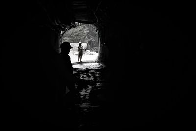 Silhouette people walking in alley amidst buildings