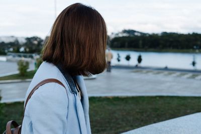 Rear view of woman against calm lake