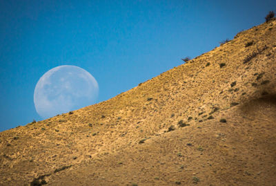 Moon rising behind a mountain