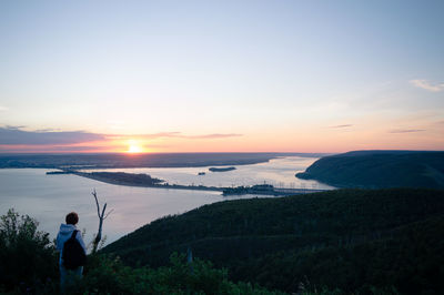 Man photographing sea at sunset