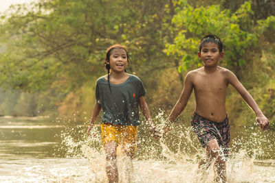 Siblings running in river