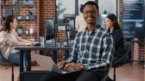 Portrait of businessman working with colleagues in office