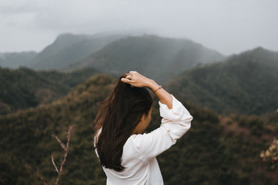 Rear view of woman standing on mountain