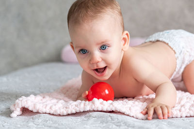 Portrait of cute baby boy lying on bed