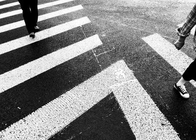 Low section of people walking on zebra crossing