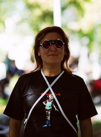 Portrait of mid adult woman wearing sunglasses standing outdoors