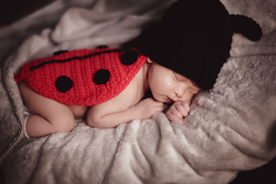 Portrait of cute baby girl lying on bed