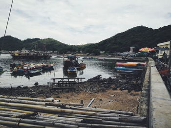 Boats moored in river against sky