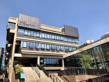 Low angle view of modern building against clear blue sky