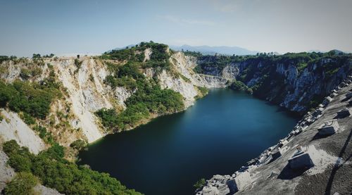 High angle view of lake amidst rocks against sky