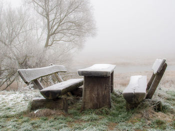 Empty bench on field during winter