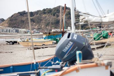 Boats moored at harbor against sky