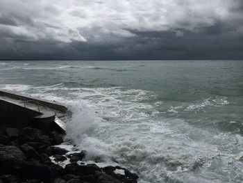 Scenic view of sea against storm clouds