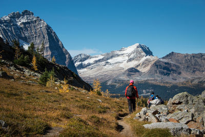 Rear view of people on snowcapped mountains against sky