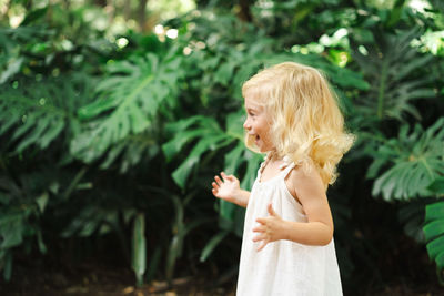 Portrait of girl standing against plants montera