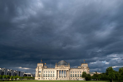 Buildings in city against cloudy sky