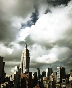 Low angle view of city against cloudy sky