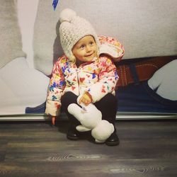 Full length of cute girl sitting at home