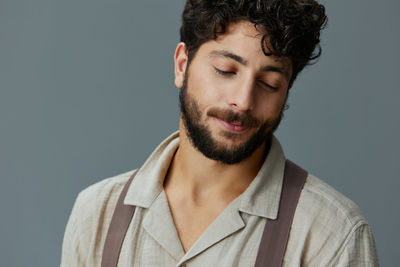 Portrait of young man against gray background