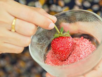 Close-up of hand holding strawberry