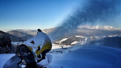 Man skiing on snow covered mountain against sky